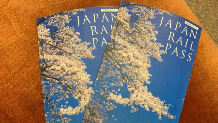Two Japan Rail Passes with the image of cherry blossoms on the front.