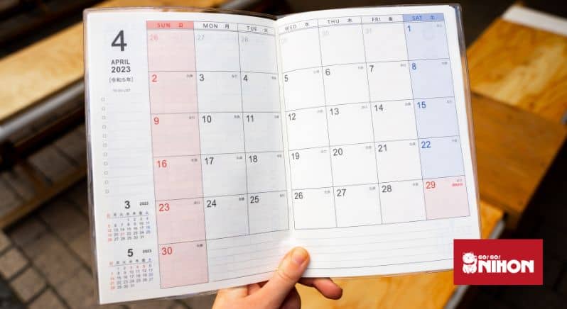Bild på en person som håller upp en japansk kalender under månaden april