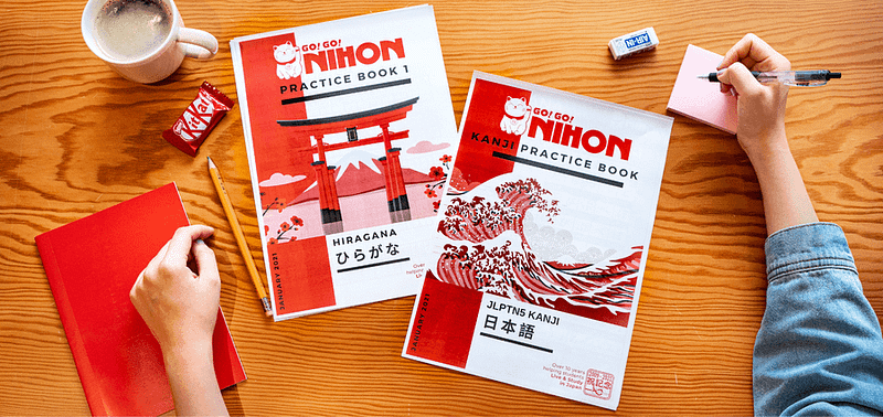 Go! Go! Nihon's gratis japanska kursböcker ligger på ett skrivbord.