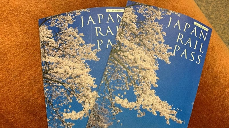 Zwei Japan Rail Passes mit dem Bild von Kirschblüten auf der Vorderseite.
