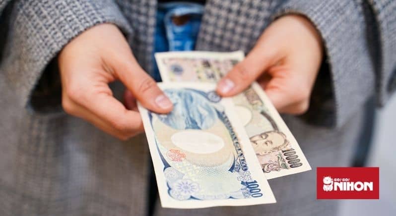 Eine Person hält japanische Yen Geldscheine in der Hand