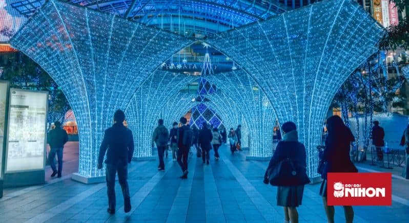 Bild von Menschen, die die blaue Beleuchtung vor dem Bahnhof Hakata in Fukuoka betrachten