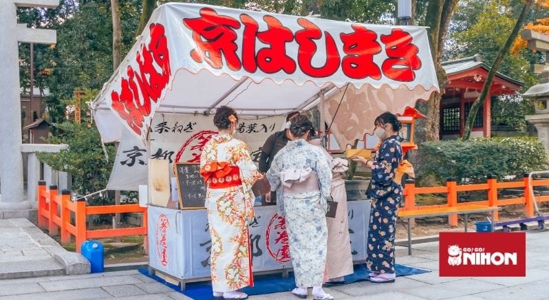 Donne in yukata davanti a una bancarella di cibo in Giappone
