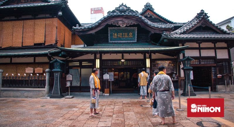 Image of people wearing yukata outside of Dogo Onsen in Matsuyama, Japan