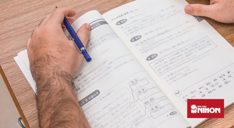 Student studying Japanese with open Japanese textbook
