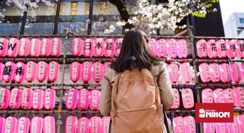 student with backpack in front of pink lanterns