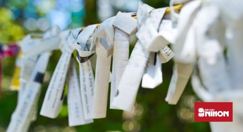 bad fortune omikuji tied up on string at temple