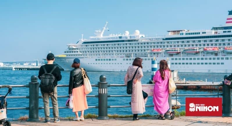 Menschen stehen in der Nähe eines Piers und beobachten ein Kreuzfahrtschiff in Yokohama