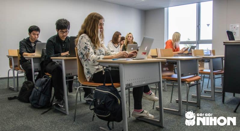 Étudiants assis à des bureaux dans une salle de classe.