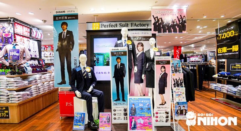Cartelloni con pubblicità di abiti eleganti da ufficio in Giappone