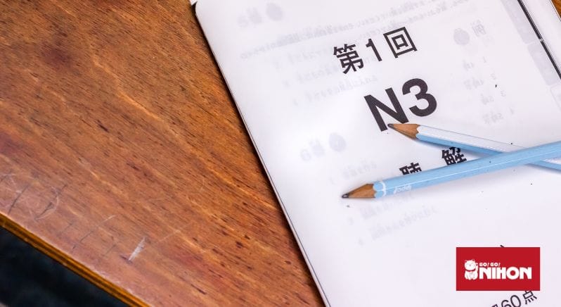 JLPT N3 test booklet on a table with two pencils. 
