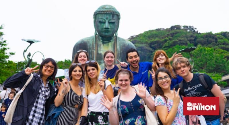 Groupe d'étudiants posant devant le Bouddha géant de Kamakura lors d'un voyage d'études au Japon.