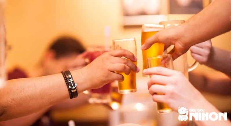 Quatre personne trinquant leurs pintes de bières dans un bar