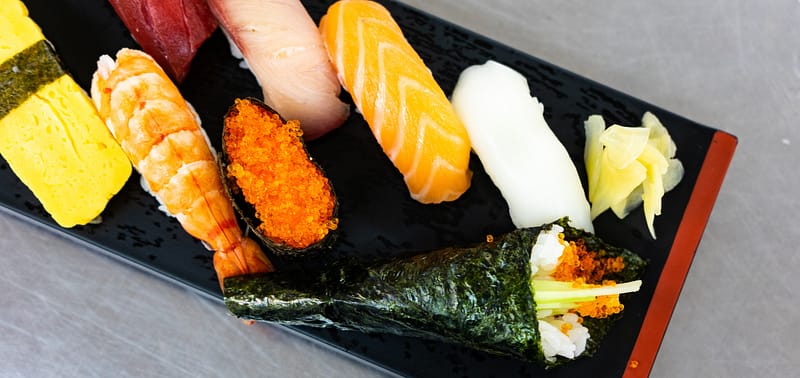 Array of Japanese sushi on a rectangle shaped plate.