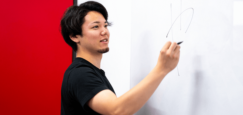 Youtuber TAKASHii writing on a whiteboard.