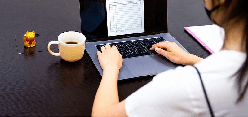 Una persona che utilizza un laptop per cambiare il loro visto di studio in un visto di lavoro in Giappone.
